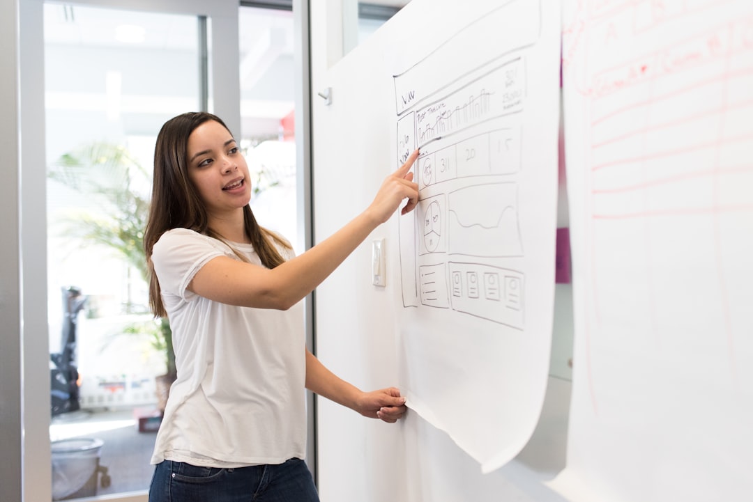 woman standing pointing paper on board